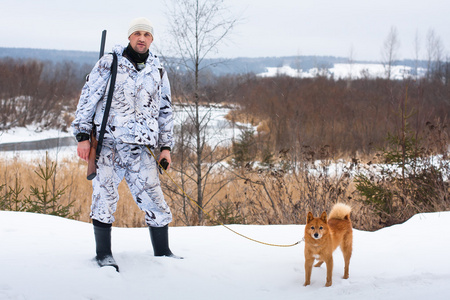 猎人和狼坐在岩石上,望着远处. 狗阿拉斯加马拉穆特.