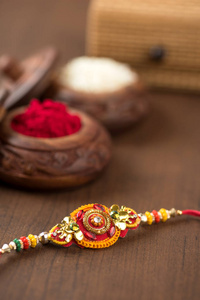 印度节日 罗刹 Bandhan 的背景优雅 Rakhi, 大米谷物和 Kumkum。一个传统的印度手腕带, 这是兄弟姐妹之间的
