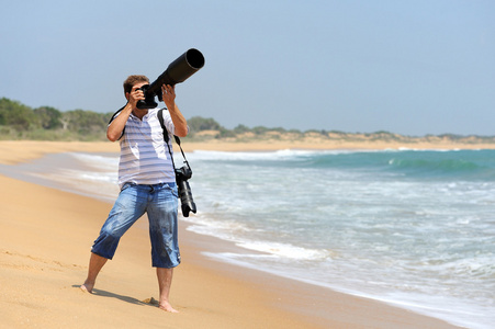 在沙滩上拍照的摄影师