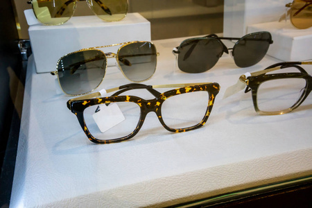 各种五颜六色的太阳眼镜在商店陈列货架上。选择性聚焦