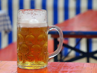 关闭巴法力亚啤酒在木桌在自然蓝色白色巴法力亚背景前面