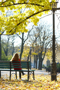孤独的女人坐在公园长椅上