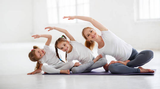 儿童练习与老师一起从事体操和瑜伽