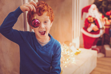 快乐的红头发男孩用圣诞捂着眼睛
