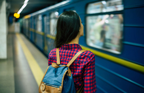 在地铁中等待火车的年轻人的背部视图照片