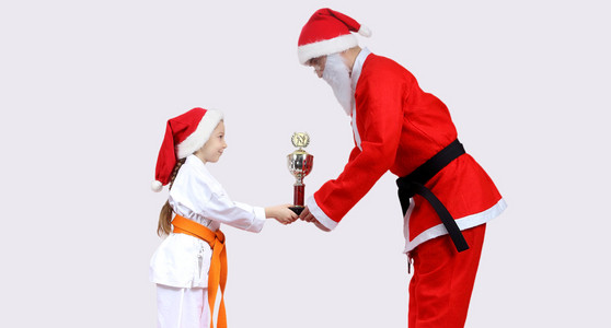 圣诞老人与黑带给小女孩在 karategi 杯的空手道
