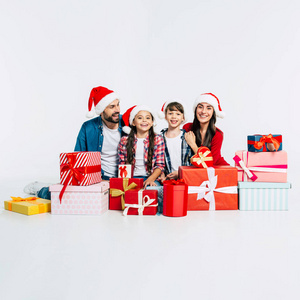 年轻的幸福的家庭与成堆的圣诞礼物在白色背景