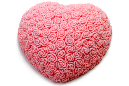 粉红色肥皂在心脏形状与小玫瑰被隔绝在白色背景上