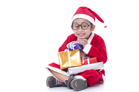 小男孩穿着圣诞老人制服与礼物