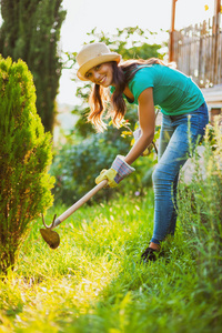 年轻快乐的女人正在锄花园