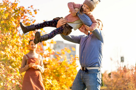 恋爱中的家庭在秋天的公园散步