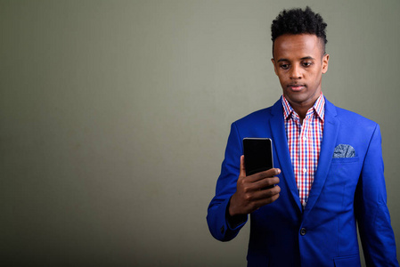 年轻英俊的非洲商人使用手机反对 co