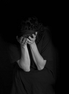 女人坐着,双手捂着脸,这是一个很难理解的概念照片