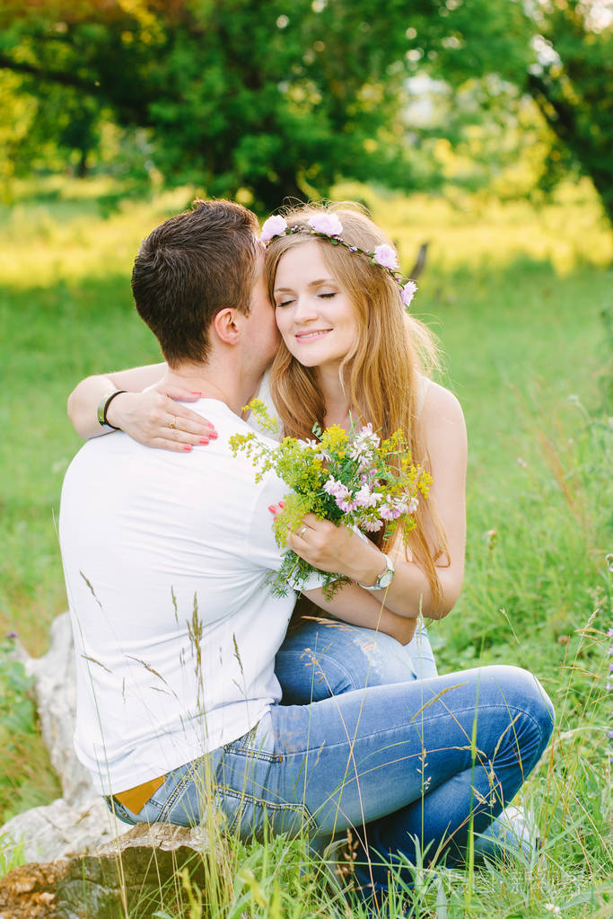 两个拥抱坐在草地上女孩的眼睛是封闭的树木在他们周围爱情故事新婚