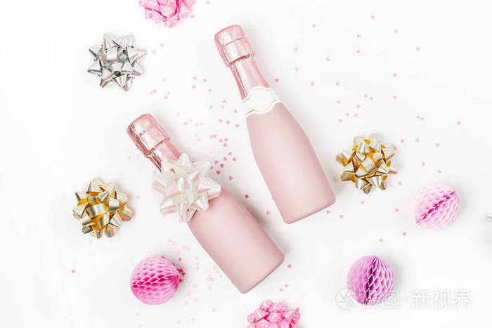 苍白的粉红迷你香槟酒瓶与装饰在白色背景