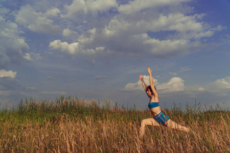 瑜伽。在自然领域的女孩练习瑜伽