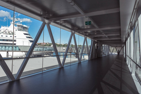 最大的口岸的国际船终端在斯德哥尔摩。去大型旅游班轮的路。旅客和乘客的隧道。从全景窗口看白色的船