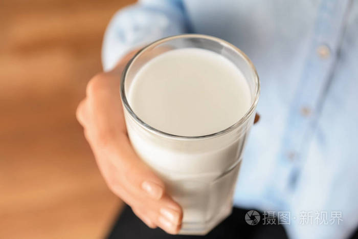 妇女拿着美味的牛奶玻璃特写镜头