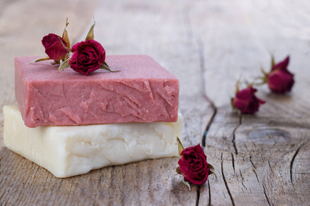 天然手工制作的肥皂与干粉红色玫瑰在老式木质背景温泉设置