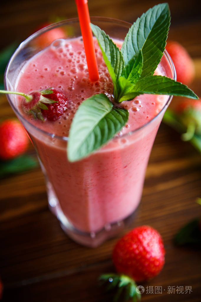 桌上的玻璃杯中的草莓鲜甜果汁