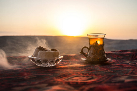 东部地毯上玻璃上的东方红茶。东方茶的概念。Armudu 传统杯。日落背景。选择性聚焦