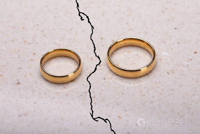 两个分开的结婚戒指在破裂的表面照片-正版商用图片08tv6v-摄图新视界