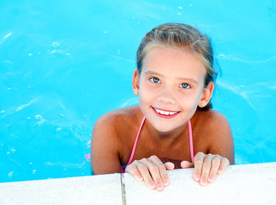 可爱的微笑快乐的小女孩在游泳池的夏天天