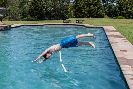 男孩跳潜水池夏天