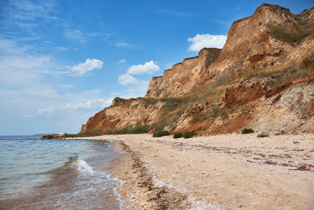 美丽的海夏天风景, 狂放的海滩特写, 海海岸与高山和多云天空