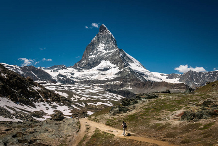 女性旅行者与背包徒步登山小径和欣赏景色雄伟的洛文兹麦特洪山在瓦莱州 Pennine 阿尔卑斯, 瑞士