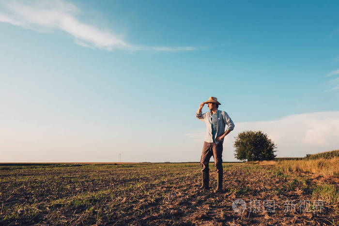 男性农民肖像站在光秃秃的田野土壤地基上, 思考和规划下一次农业活动