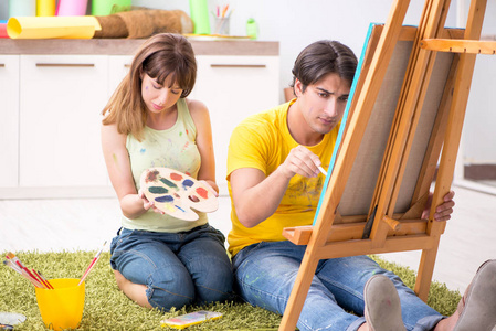 年轻夫妇享受绘画在家里