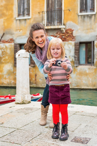 快乐妈妈和宝贝女孩拍照在威尼斯，意大利
