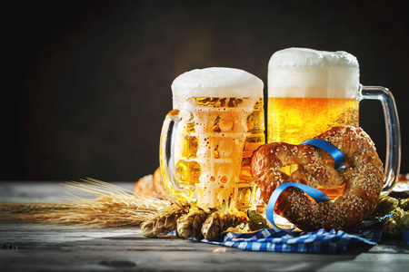啤酒杯和椒盐脆饼放在木桌上。慕尼黑。啤酒节