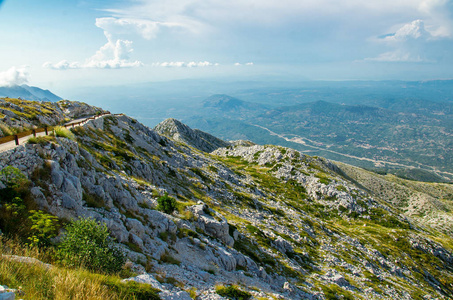 克罗地亚达尔马蒂亚, 在比奥科沃山脉的丘陵和岩石前, 在山顶上的山路, 天空和山谷多云