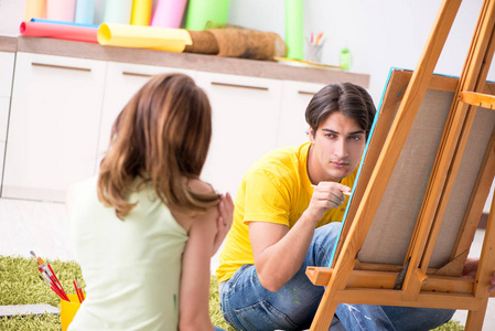 年轻夫妇享受绘画在家里