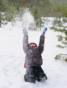 孩子在玩的雪地上森林背景图片