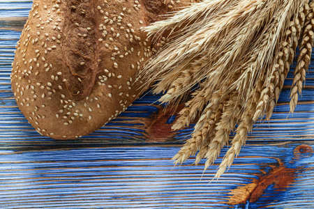 小麦耳朵棕色面包在老式木质背景