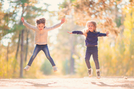 两个小女孩跳跃和乐趣一起在户外