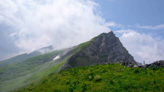 郁郁葱葱的绿色山景和山顶, 在瑞士阿尔卑斯山靠近库尔的地方, 有浅白云和陡峭的悬崖落差