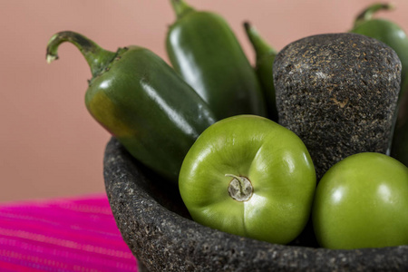 典型的墨西哥菜, 在五颜六色的餐桌上配酱汁。molcajete 石与辣椒和绿色西红柿细节