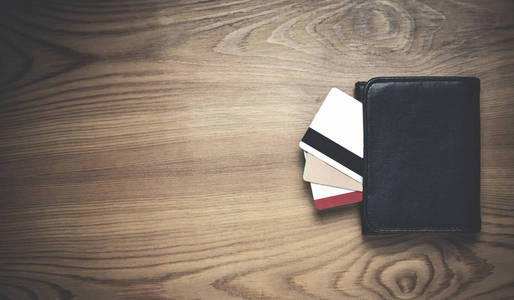 黑色钱包与信用卡的木材背景