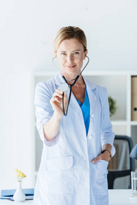 微笑成人女医生在白大衣检查在办公室听诊器