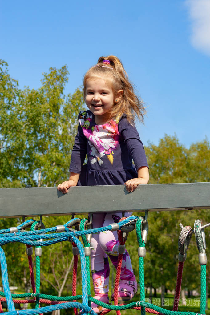 小女孩在夏天爬上绳索梯子