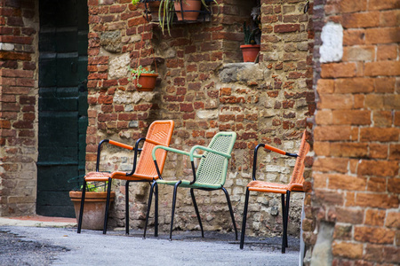 意大利皮恩扎小镇意大利老房子外的复古板凳.植物装饰照片