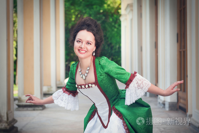 美丽的女人，穿着绿色中世纪做屈膝礼