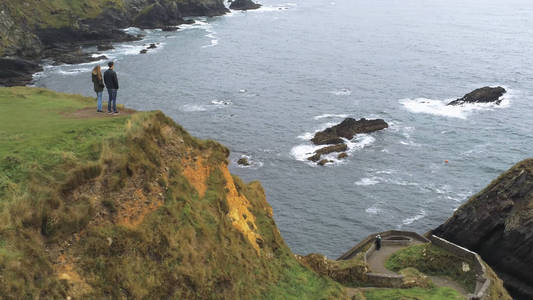 Dunquin 码头上的一对夫妇站在爱尔兰西海岸的鸟瞰图