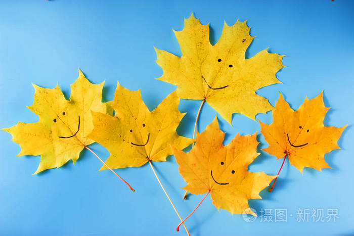 微笑的叶子在蓝色背景.秋季理念