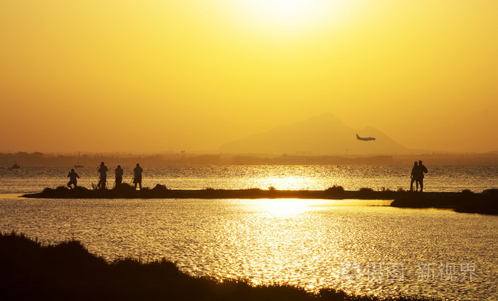 在日落时在海边的人摄影飞机