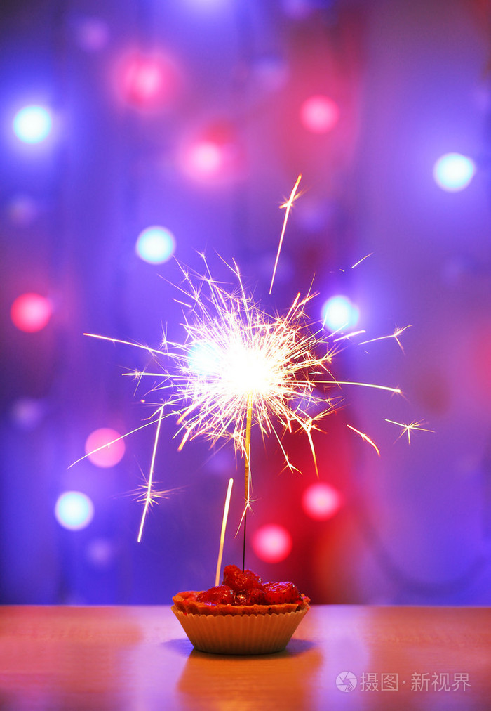 与烟火闪亮背景上的美味蛋糕